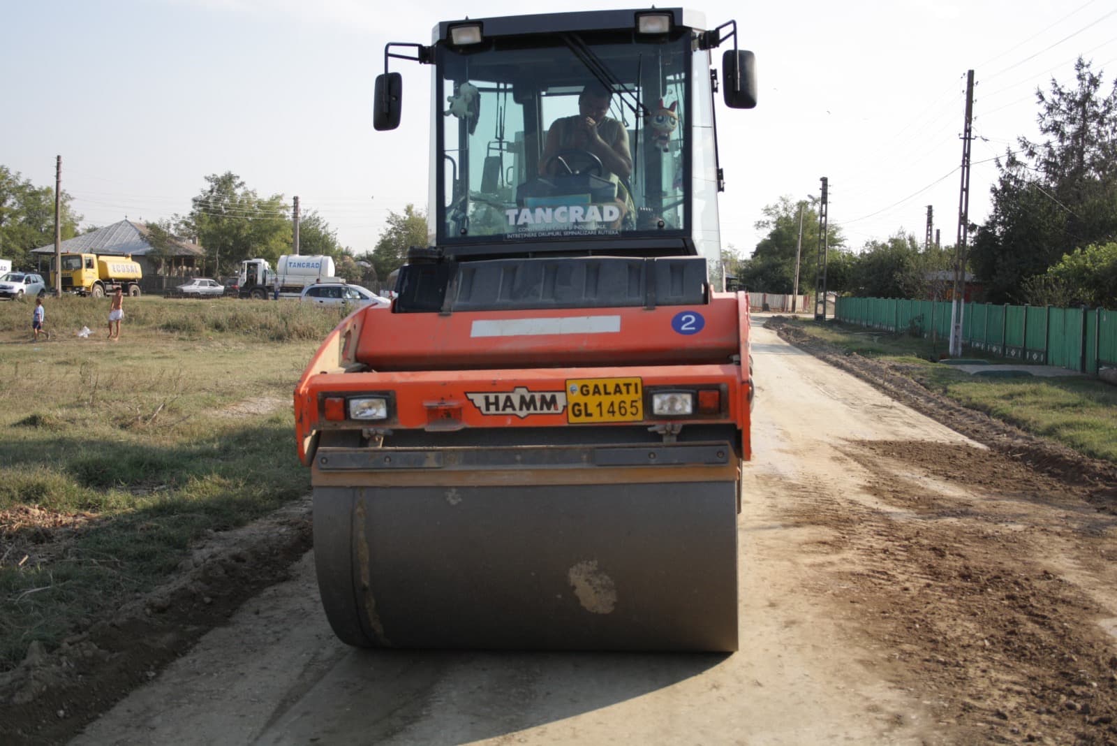 Compactor tandem pe strada comunală în curs de stabilizare